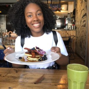 Black girl holding pancakes at Anna Loka
