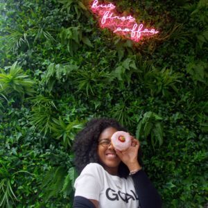 Black girl holding a donut at Blanche Bakery