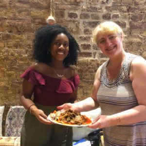 Black girl and white lady holding a plate of food
