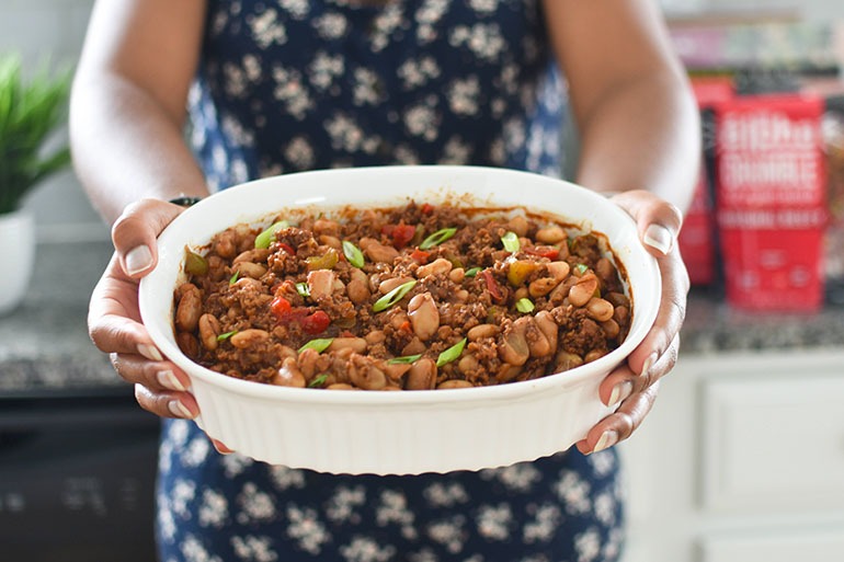 Women holding Vegan Beefy Homemade Baked Beans from Scratch in bowl