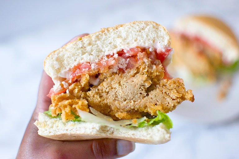 Atlas Monroe Vegan Fried Chicken sandwich with brown hand