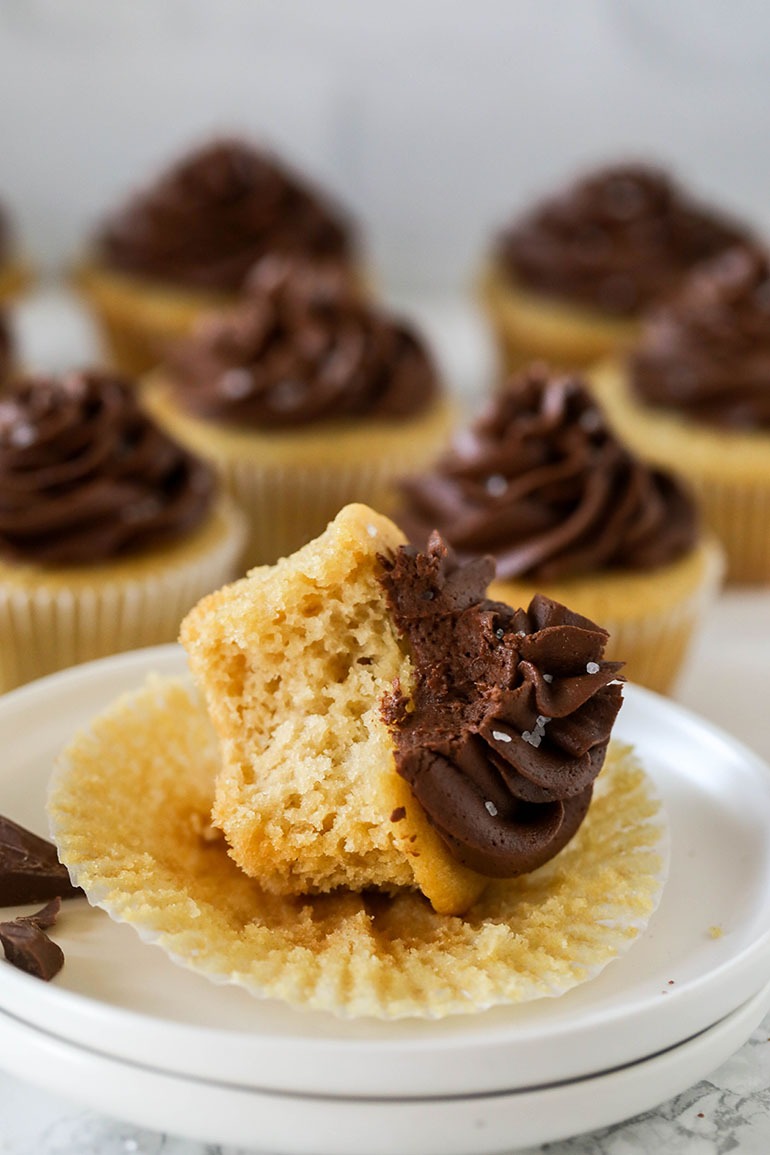 Vegan Yellow Cupcakes with Chocolate Frosting on two plates tilted over