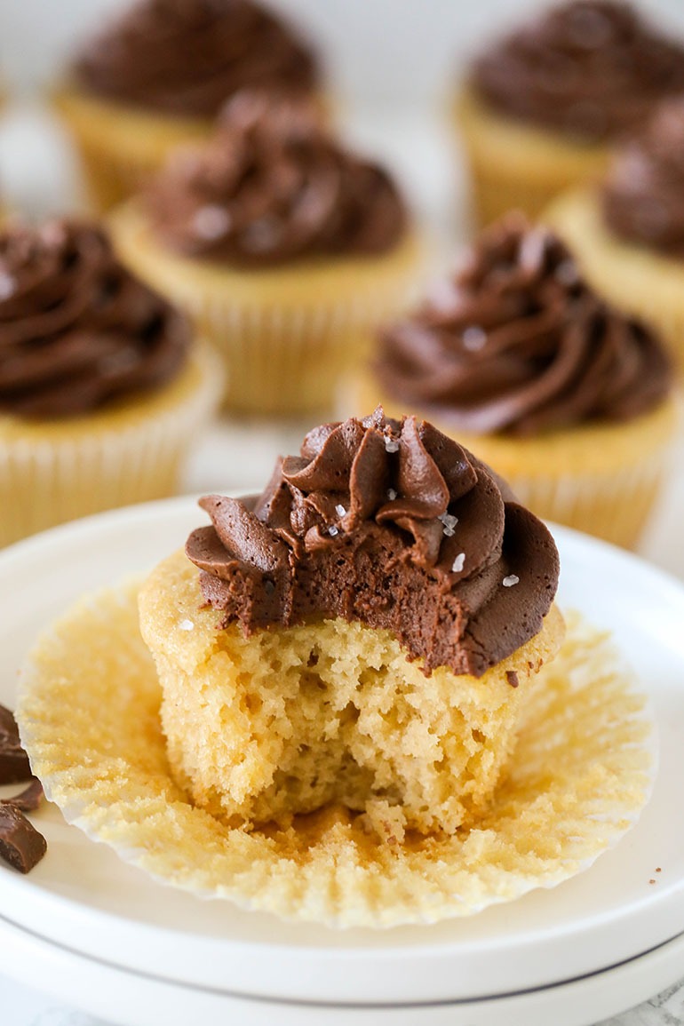 Vegan Yellow Cupcakes with Chocolate Frosting with bite missing