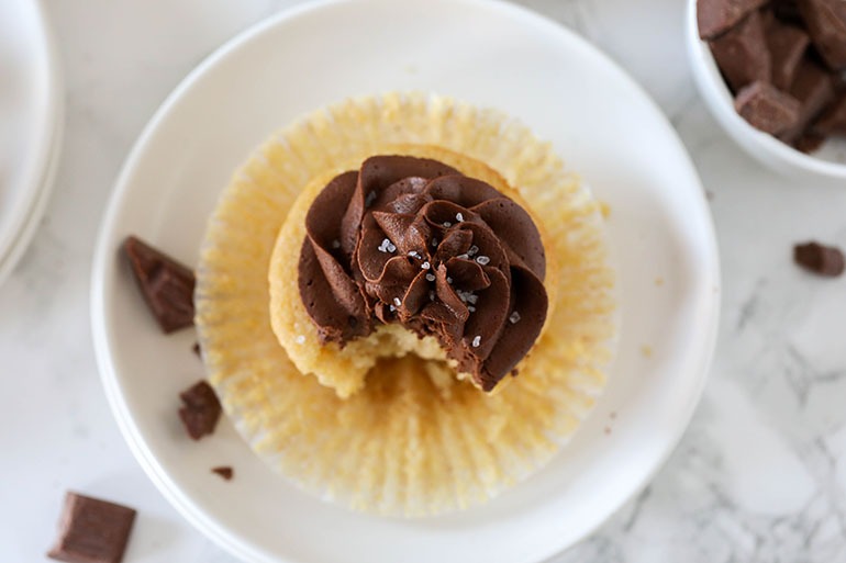 Vegan Yellow Cupcakes with Chocolate Frosting on small white plate
