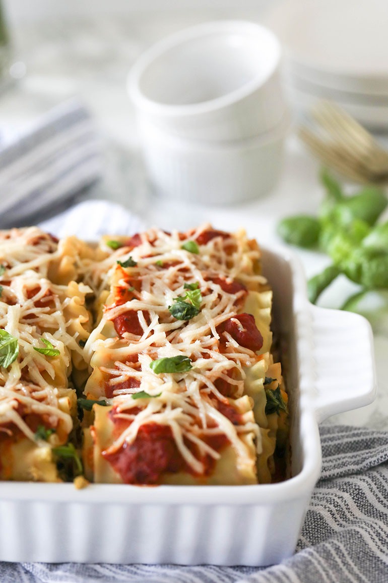 Vegan Spinach Lasagna Rolls with Almond Ricotta in white square baking dish