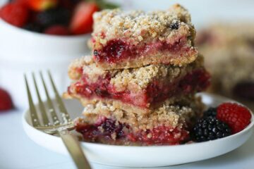 Stacked Vegan Triple Berry Crumb Bars on white plate