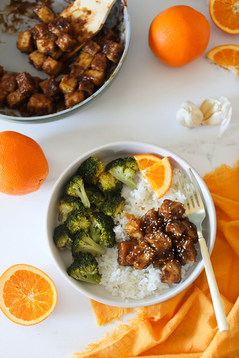 Vegan Orange Tofu in white bowl with broccoli 