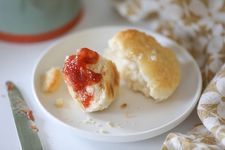 Vegan Buttermilk Biscuit on white plate with strawberry jelly