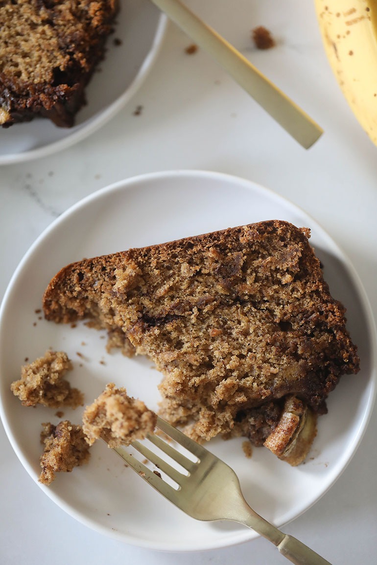 Vegan Cinnamon Banana Bread on a white plate with gold fork