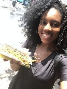 Black girl with grilled corn