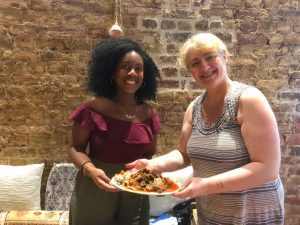 Black girl and white lady holding a plate of food