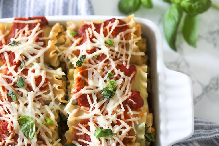 Vegan Spinach Lasagna Rolls with Almond Ricotta in white square baking dish