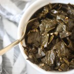 Vegan Collard Greens in white bowl with gold fork