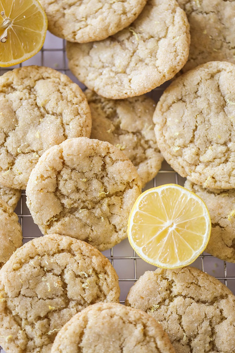 Vegan Lemon Sugar Cookies on a cooling rack with sliced lemons