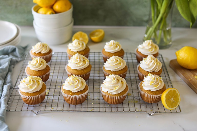 Vegan Lemon Cupcakes on wire cooling rack with lemons
