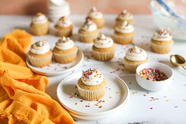 Vegan Vanilla Cupcakes on white plate with sprinkles