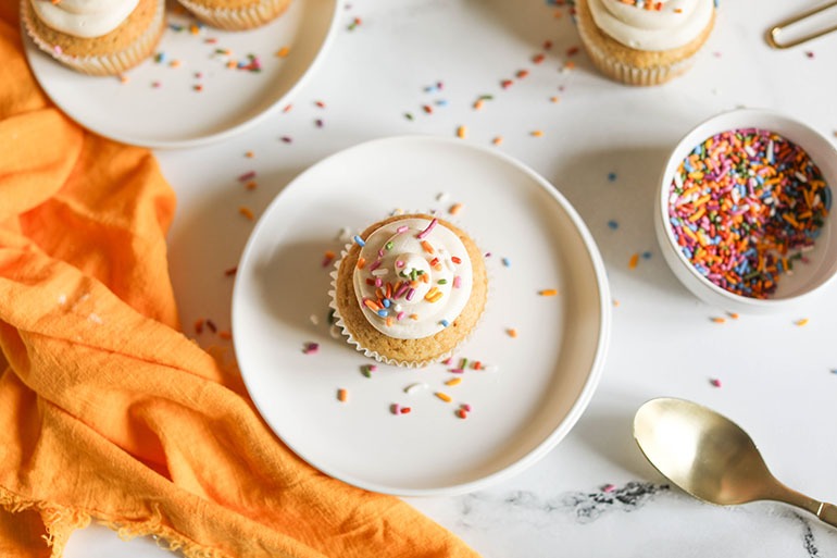 Vegan Vanilla Cupcakes on white plate with sprinkles