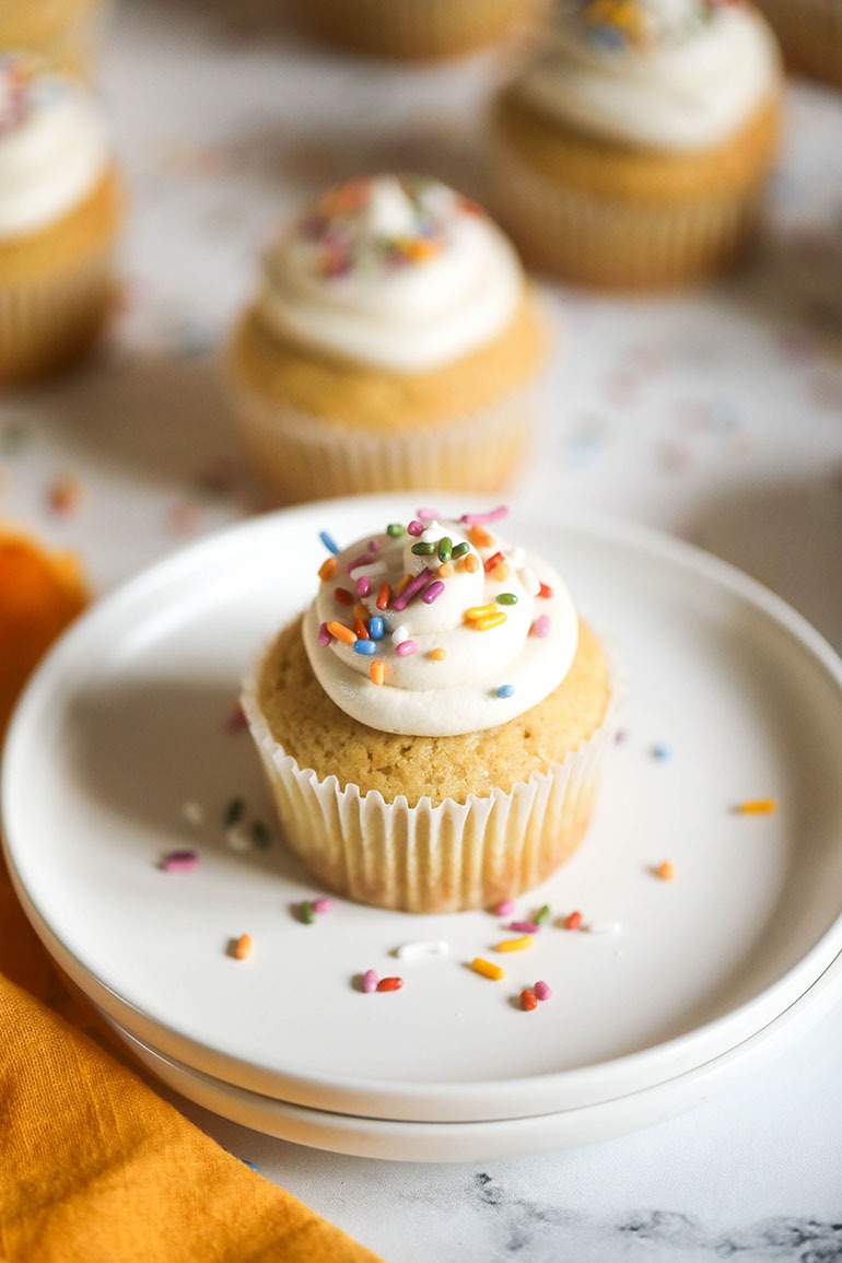 Vegan Vanilla Cupcakes on white plate with sprinkles