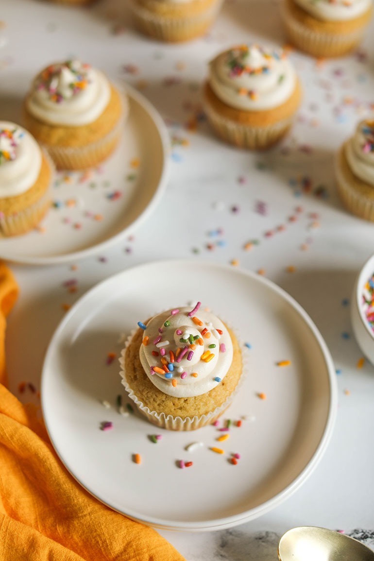 Vegan Vanilla Cupcakes on white plate with sprinkles