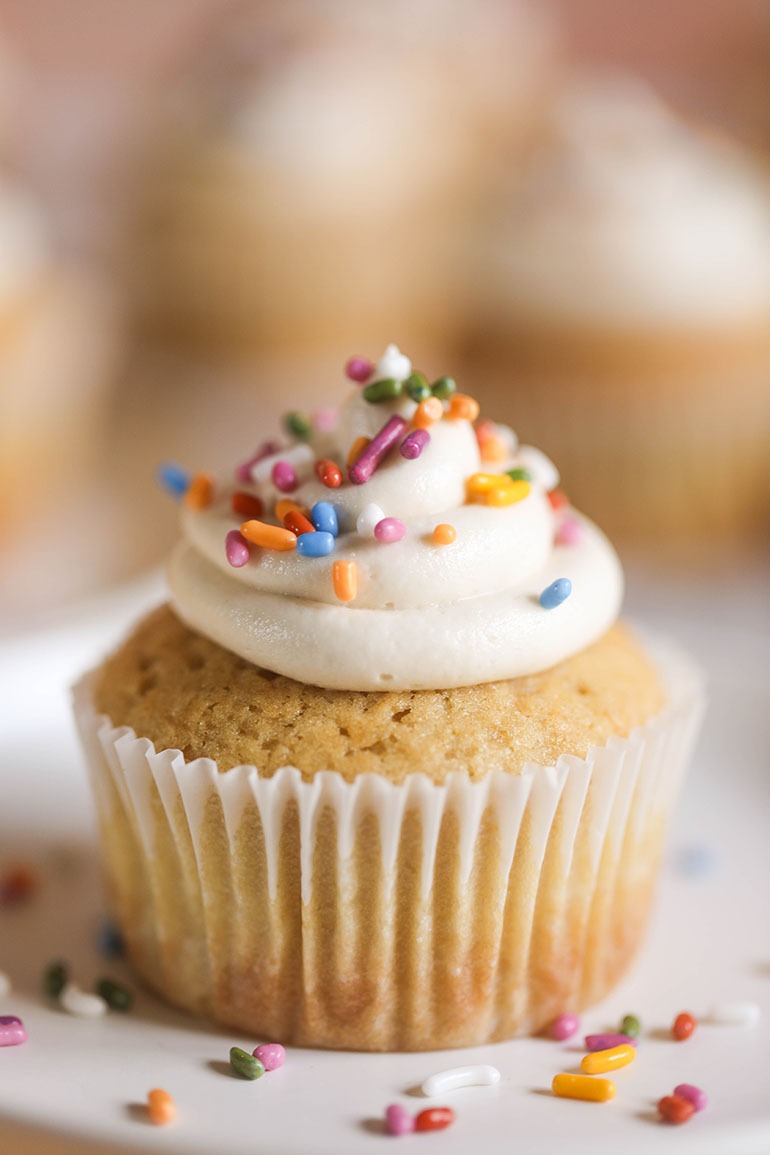 Vegan Vanilla Cupcakes on white plate with sprinkles