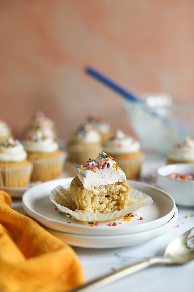 Vegan Vanilla Cupcakes on white plate with sprinkles