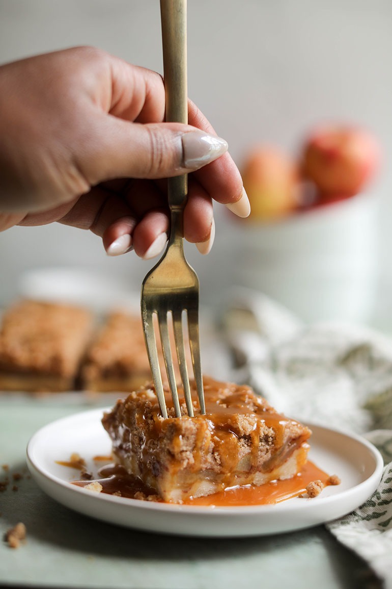 Vegan Caramel Apple Pie Bars on white plate with gold fork